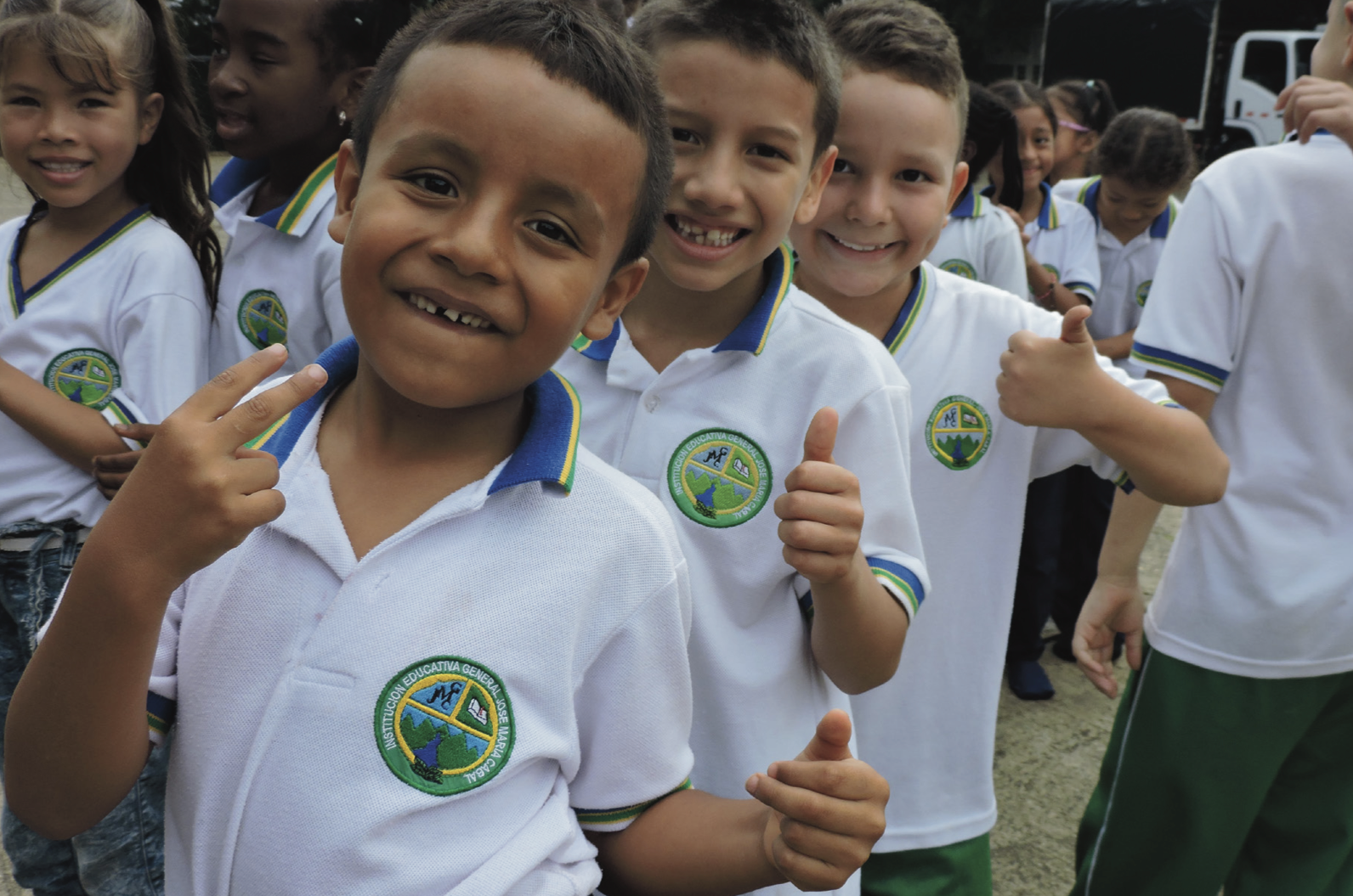 Colombian students giving thumbs-up in school uniforms